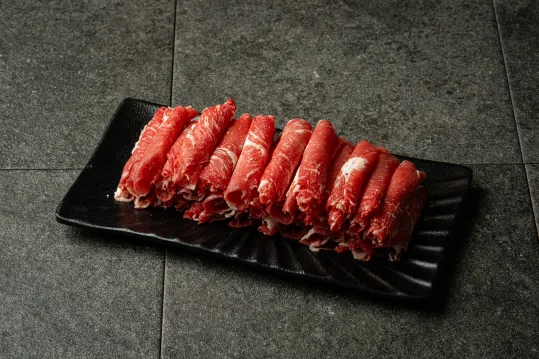 검은 접시에 담은 얇게 썬 소고기